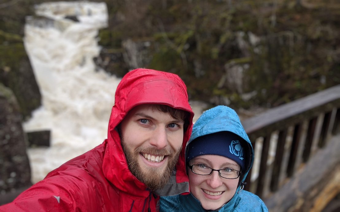 Chelsi and Guy on the bridge at Bracklinn falls. A very swollen waterfall can be seen behind them.