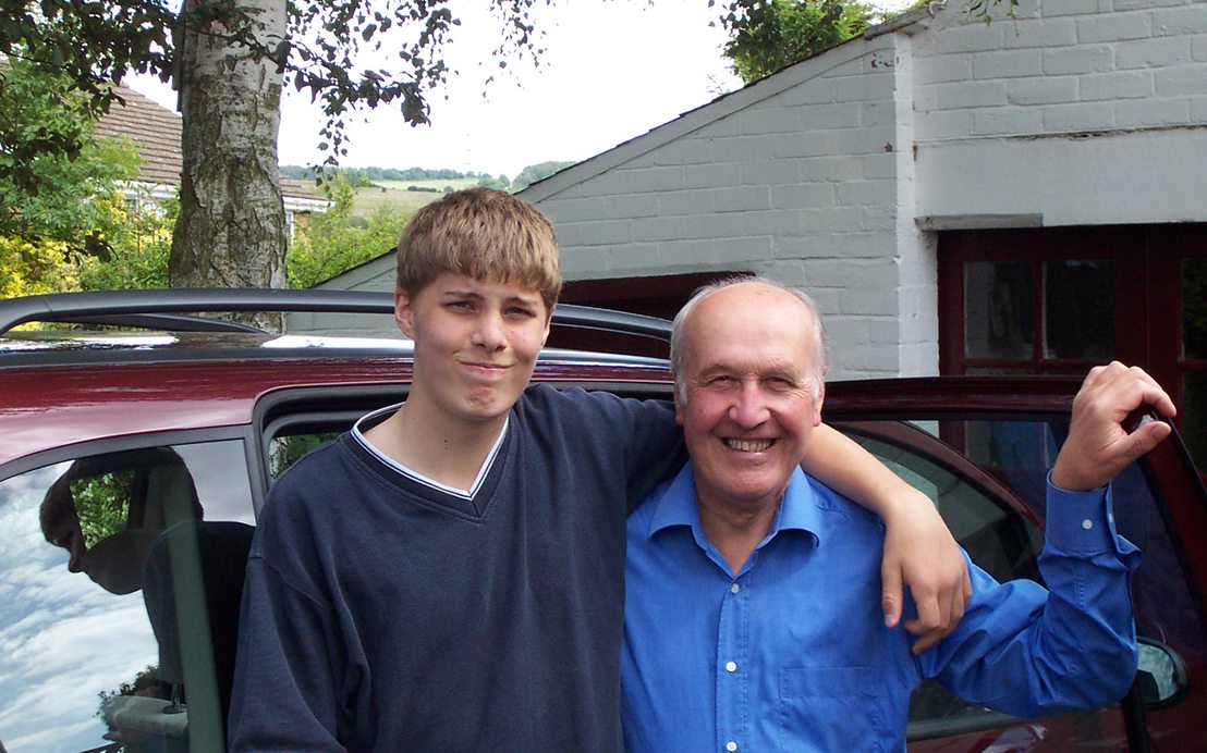 A teenage Guy with his arm around Maving in front of a car