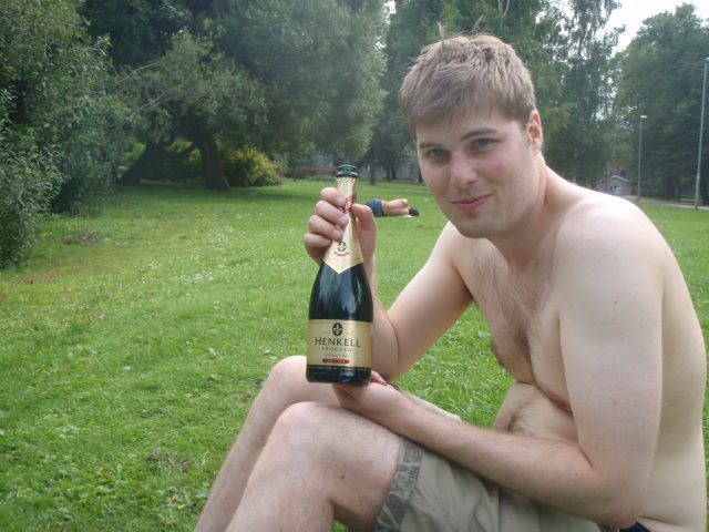 Shirtless Guy in a park with a cheap bottle of Champagne