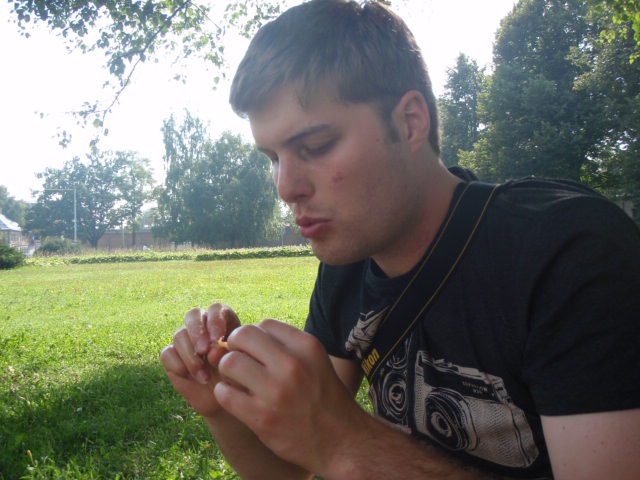 Guy eating in a park after visiting a local market