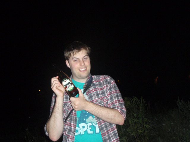 Guy inebriated posing with a bottle of beer