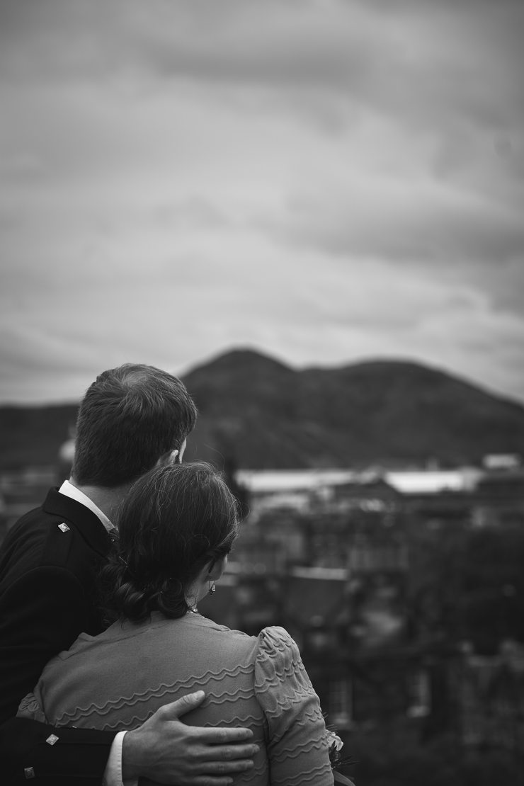 The couple from behind looking out over the Edinburgh skyline.